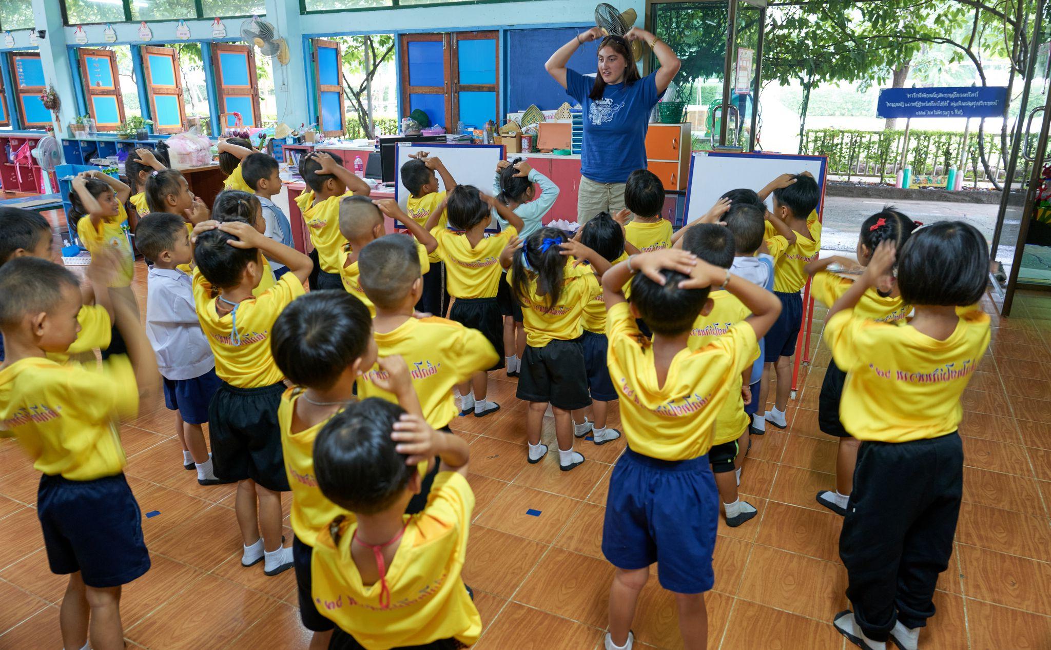 Student volunteer teaching a classroom of elementary students